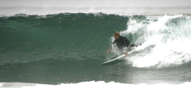 Surfer grabbing the board on a Sands Beach wave