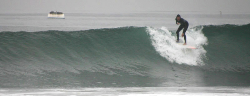 Surfer making a long drop at Sands Beach